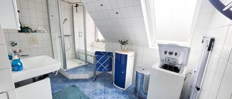 Un bagno moderno con doccia, lavandino e WC.