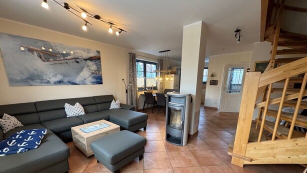 Ein Wohnzimmer mit Sofa, Hocker und Kamin.