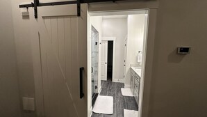 A hallway with a sliding door, a thermostat, and a tiled floor. - Modern New 3bd/3.5ba Close To Everything! (Jeffersonville)