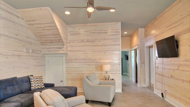 A modern living room with a sofa, armchair, and a lamp. - In-town coastal getaway, with a heated pool & level 2 Tesla EV charger on site. (Port Aransas)