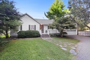 A single-story house with a front porch, a garage, and a well-maintained lawn.