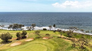 Een kustgolfbaan met bunkers en een helder uitzicht op de oceaan.