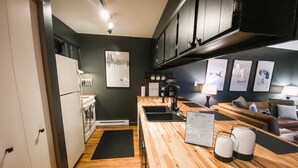 Una cocina moderna con encimeras de madera, horno integrado y estación de café.