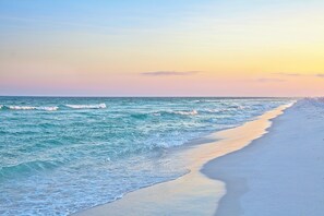 A beach with waves and a clear sky.