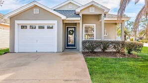 A two-story house with a garage, a front door, and a small porch.