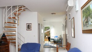 A spacious living area with a staircase, a dining table, and blue sofas. - Beautiful Apartment with Sea View, Trogir, Croatia (Mastrinka)