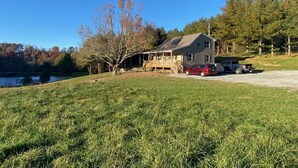 Une maison avec un porche, une allée et deux voitures garées.