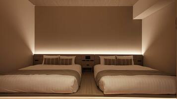 Ein modernes Hotelzimmer mit zwei Betten, Holzboden und minimalistischem Design.