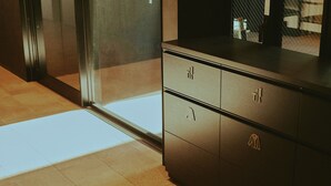 Una cocina moderna con una encimera oscura, un refrigerador de acero inoxidable y un piso con baldosas.