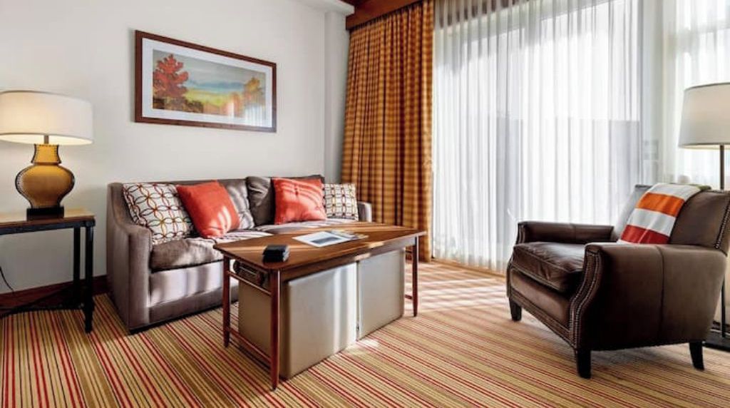 A living room with a sofa, armchair, coffee table, and lamps.
