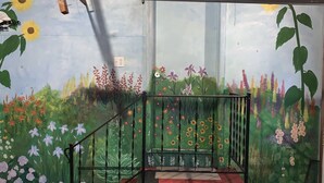 A staircase with a railing, surrounded by a mural of various flowers and plants.