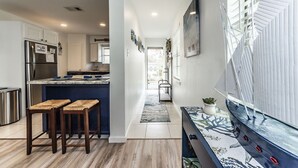 Una cocina moderna con una isla integrada, electrodomésticos de acero inoxidable y una zona de estar con taburetes.