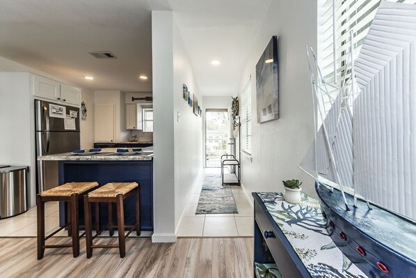 A modern kitchen with a built-in island, stainless steel appliances, and a seating area with stools.