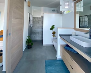A modern bathroom with a shower, toilet, and sink. - Villa NALA by the Sea with a Pool: Relax with a View of the Lagoon, Feet in the Water (LE ROBERT)