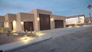 Un bâtiment moderne doté de plusieurs portes de garage, d’une allée aménagée et d’un éclairage extérieur.
