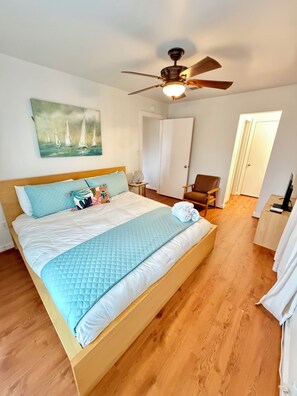 A bedroom with a bed, a ceiling fan, a painting, a chair, and a door. - LA Tortuga, Beachside house in sought after Pirates Beach, Galveston TX (Galveston)