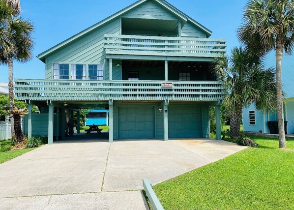 A two-story building with a covered front porch and a garage.