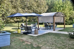 Relax in a serene outdoor space with a covered seating area, umbrellas, and comfortable seating options.