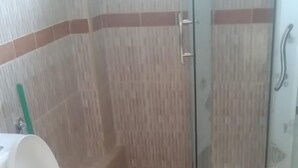 Een badkamer met toilet, wastafel en douchecabine.