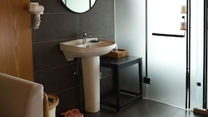 A modern bathroom with a round mirror, white sink, and a black-framed table. - Paradise hotspring hotel (Chenzhou)