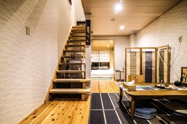 Un interior moderno con una escalera de madera que lleva a un dormitorio.