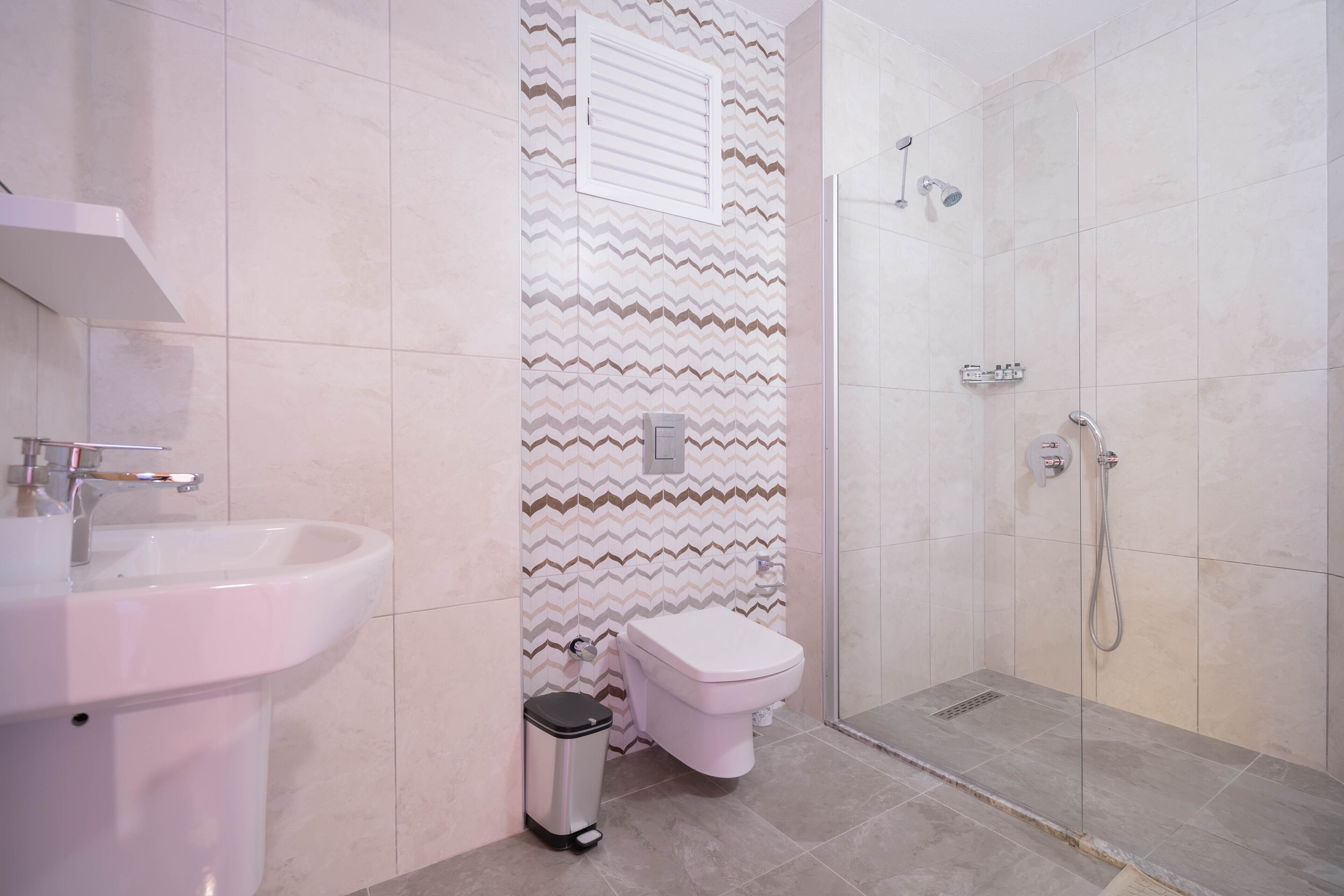 Un baño con lavamanos, inodoro y ducha.