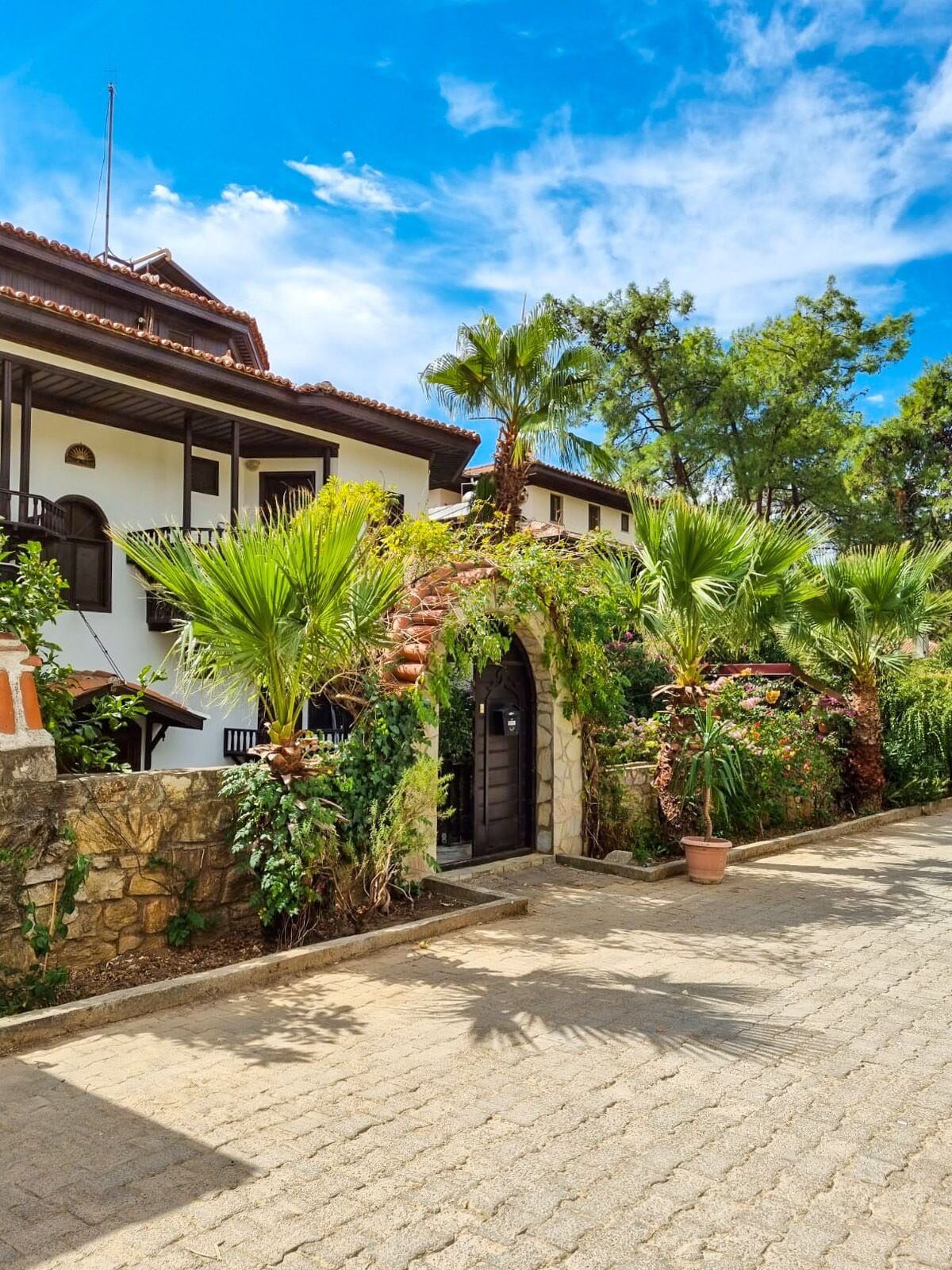 Un edificio tradicional con tejado de tejas, pared de piedra y patio empedrado.
