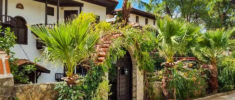 Un edificio tradicional con tejado de tejas, pared de piedra y patio empedrado.