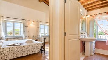 Une chambre à coucher avec un lit, une table de chevet et une fenêtre.