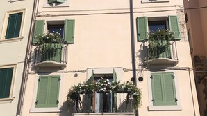 A building with multiple balconies, green shutters, and a central entrance door. - Apartment La Piu' Bella Verona (Verona)