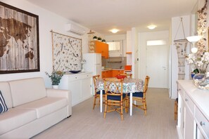 Cozy living space with a dining area, featuring a sofa, dining table, and kitchen.