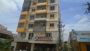 A multi-story building with a sign for 'Siri Delight Boarding & Lodging' and 'Navya Cake Palace'. - Siri Delight (Bengaluru)