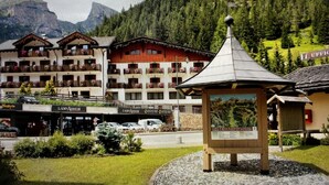 A hotel with multiple balconies, a mountain view, and a small pavilion in the foreground. - Hotel Piz Boè (Mazzin)