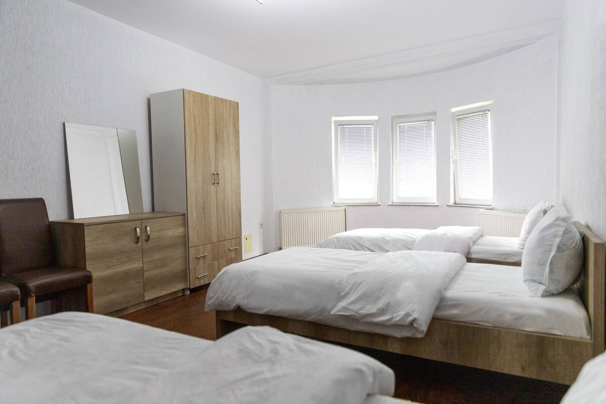 Ein Schlafzimmer mit zwei Betten, einem Holzschrank und einem Stuhl.