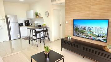 Familieleilighet, 2 soverom, hageområde | Oppholdsområde | En 55-tommers Flatskjerm-TV med kabel-kanaler samt TV