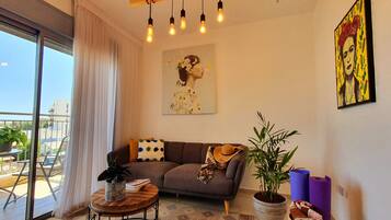 Appartamento Design, 1 camera da letto, vista spiaggia | Area soggiorno | TV a schermo piatto 55 pollici con canali via cavo, TV