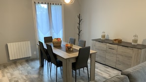 A modern dining area with a wooden table, black chairs, and a grey sofa. - The house of pech dordogne (Coux-et-Bigaroque-Mouzens)