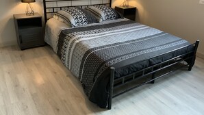 A bed with a metal frame, two bedside tables, and patterned bedding. - The house of pech dordogne (Coux-et-Bigaroque-Mouzens)