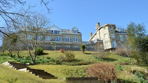 A large, multi-story building with a prominent entrance and a staircase leading up to the main entrance.