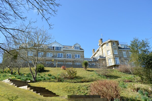 A large, multi-story building with a prominent entrance and a staircase leading up to the main entrance.