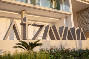 A modern building facade with geometric patterns and a palm tree in the foreground. - Atzavara Hotel Spa (Santa Susanna)