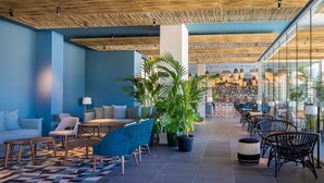 A modern lobby with a checkered floor, seating areas, and a bar in the background. - Atzavara Hotel Spa (Santa Susanna)
