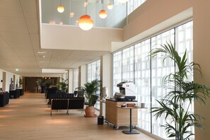 A spacious indoor area with a coffee machine, seating, and large windows. - Atzavara Hotel Spa (Santa Susanna)