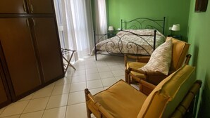 A room with a bed, a chair, a wardrobe, and a window with curtains. - The Patio near Bergamo with a summer pool (Mozzo)