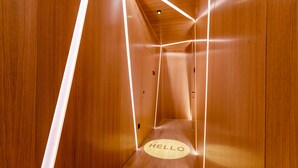 Un couloir étroit, en bois, avec l’inscription « BONJOUR » peinte sur le sol.