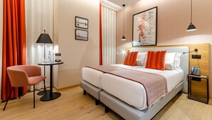 Une chambre d’hôtel avec un lit, une chaise, une table et une table de chevet.