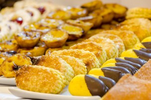 Une variété de pâtisseries, notamment des tartes et des douceurs enrobées de chocolat, présentées sur une assiette.