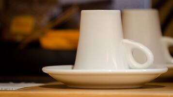 Una taza y platillo de cerámica blanca sobre una superficie de madera.