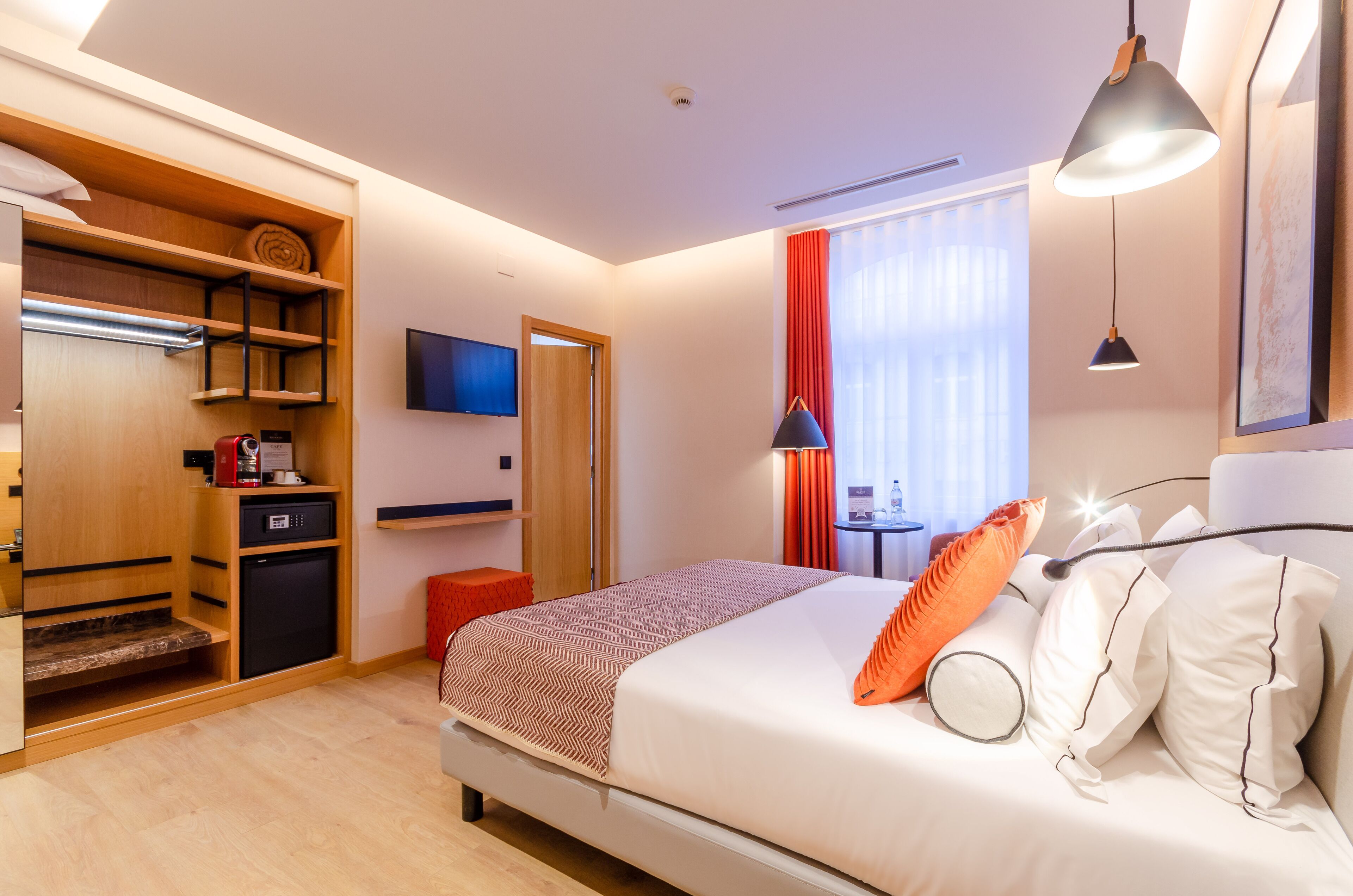 Una habitación de hotel con cama, televisión, escritorio y armario.