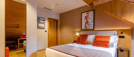 Un dormitorio moderno con una cama grande, techo de madera y un área de baño visible.